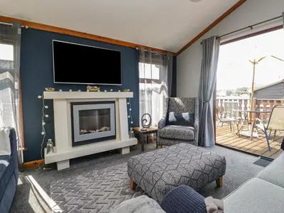 a living room with a fireplace and a tv at Sunset Retreat in Carnforth
