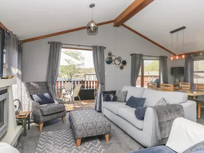 a living room with a white couch and chairs at Sunset Retreat in Carnforth