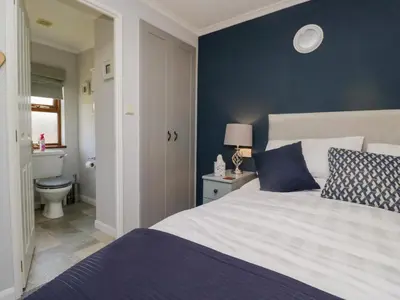 a bedroom with a bed and a bathroom with a toilet at Sunset Retreat in Carnforth