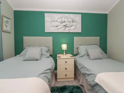 two twin beds in a room with green walls at Sunset Retreat in Carnforth