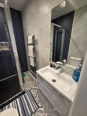 a bathroom with a white sink and a shower at Spacious New Studio in Blackburn Town Centre in Blackburn
