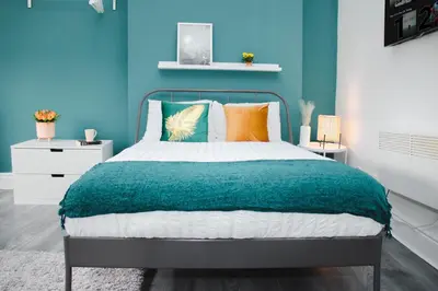 a bedroom with a bed with a blue wall at Contractor Studio - Liverpool L5 - Sleeps 3 in Liverpool