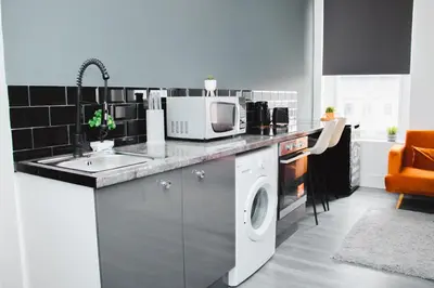 a kitchen with a washing machine and a microwave at Contractor Studio - Liverpool L5 - Sleeps 3 in Liverpool
