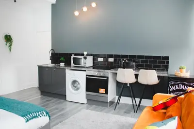 a kitchen with a washing machine and a microwave at Contractor Studio - Liverpool L5 - Sleeps 3 in Liverpool
