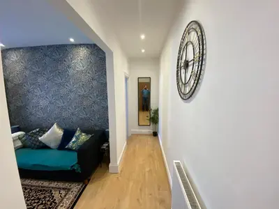 a living room with a couch and a clock on the wall at The Fortress in Lytham St Annes