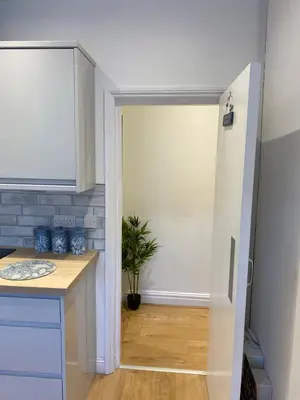 a kitchen with a door leading into a kitchen with a plant at The Fortress in Lytham St Annes