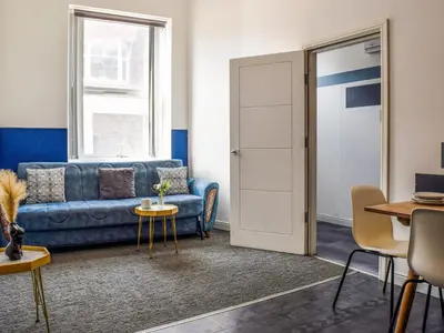 a living room with a blue couch and a table at South Pier Apartment in Blackpool