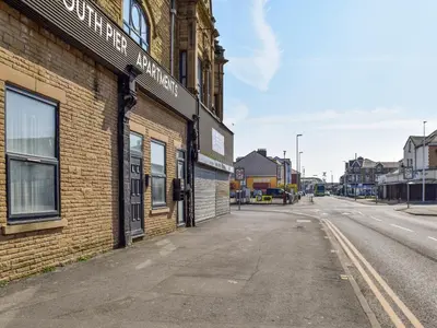 an empty street next to a brick building at South Pier Apartment in Blackpool