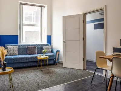 a living room with a blue couch and a table at South Pier Apartment in Blackpool
