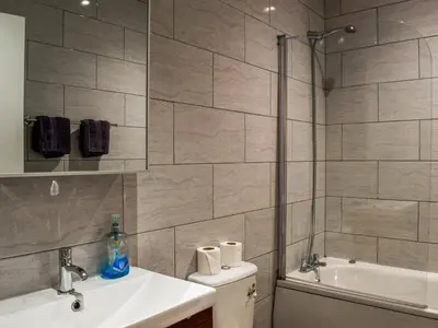 a bathroom with a shower and a sink and a tub at South Pier Apartment in Blackpool