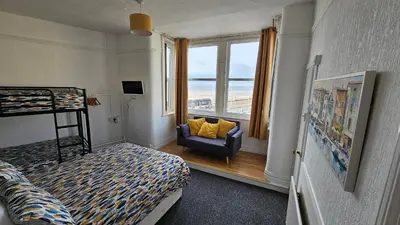a bedroom with a bed and a chair and a window at 6 Cocker Square in Blackpool