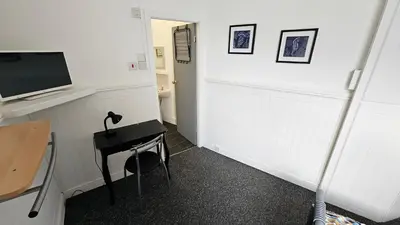 a room with a desk and a tv on a wall at 6 Cocker Square in Blackpool