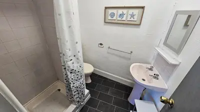 a bathroom with a sink and a toilet and a shower at 6 Cocker Square in Blackpool