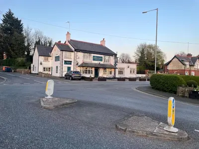 a street with two signs in the middle of a road at Night Owl Cottage in Rainford