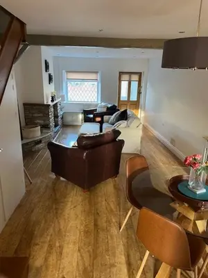 a living room with a couch and a table at Night Owl Cottage in Rainford