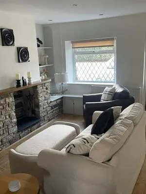 a living room with a white couch and a fireplace at Night Owl Cottage in Rainford