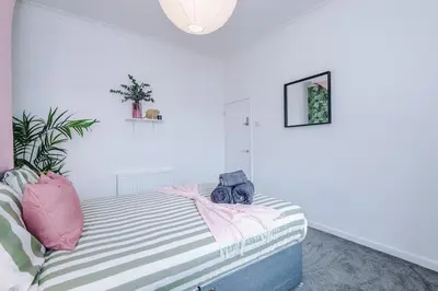 a bedroom with a bed with pink and stripes at #17 Walk to Anfield Stylish House for 12 in Liverpool