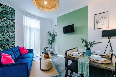 a living room with a blue couch and a table at #17 Walk to Anfield Stylish House for 12 in Liverpool