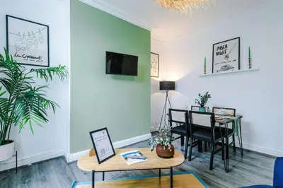 a living room with a table and a dining room at #17 Walk to Anfield Stylish House for 12 in Liverpool