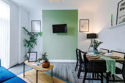 a living room with a table and a blue couch at #17 Walk to Anfield Stylish House for 12 in Liverpool