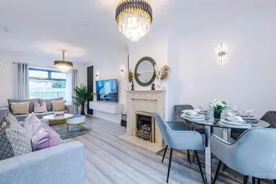 a living room with a table and a fireplace at New 2 Bed House - Perfect for Contractors & Families In St Helens Weekly & Monthly Stays in Saint Helens