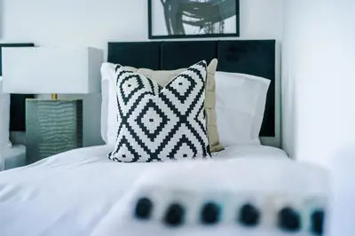 a white bed with a black headboard and pillows at New 2 Bed House - Perfect for Contractors & Families In St Helens Weekly & Monthly Stays in Saint Helens