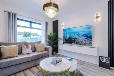 a living room with a couch and a tv on a wall at New 2 Bed House - Perfect for Contractors & Families In St Helens Weekly & Monthly Stays in Saint Helens