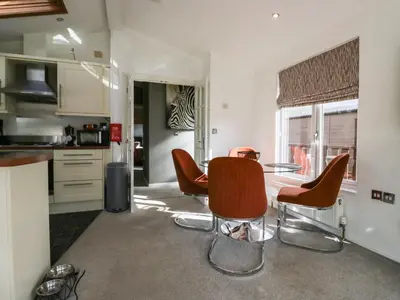 a kitchen with a table and chairs in a room at Gressingham View Lodge in Carnforth