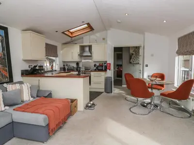 a living room and kitchen with a couch and a table at Gressingham View Lodge in Carnforth