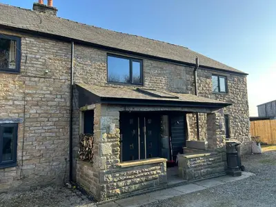 an old brick house with a large door at Oswaldtwistle Farmhouse in Oswaldtwistle