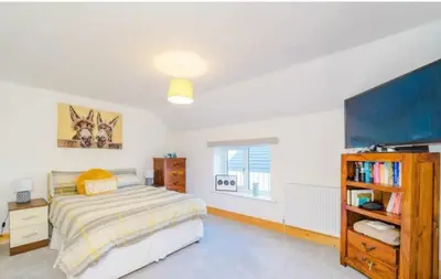 a bedroom with a bed and a flat screen tv at Oswaldtwistle Farmhouse in Oswaldtwistle