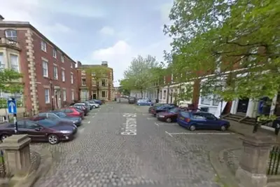 a city street with cars parked in a parking lot at Stylish City Centre Apartment With Parking in Preston