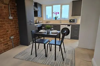 a kitchen with a table and chairs in a kitchen at Stylish City Centre Apartment With Parking in Preston