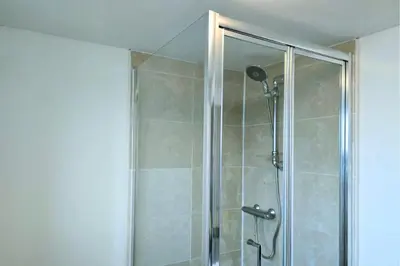 a shower with a glass door in a bathroom at Stylish City Centre Apartment With Parking in Preston