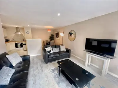 a living room with a couch and a flat screen tv at 2BR City Centre Apt - Balcony - Sleeps 6 in Liverpool