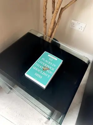 a book sitting on top of a glass table at 2BR City Centre Apt - Balcony - Sleeps 6 in Liverpool