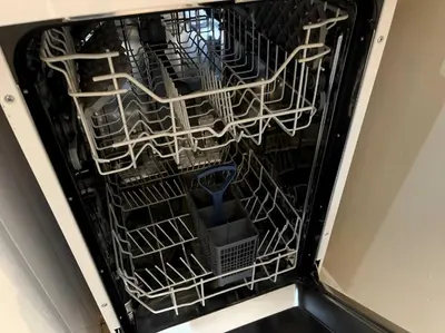 an empty dishwasher with a blue spoon in it at 2BR City Centre Apt - Balcony - Sleeps 6 in Liverpool