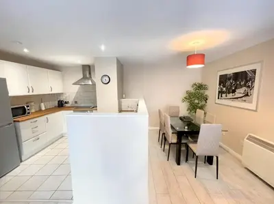 a kitchen and dining room with a table and chairs at 2BR City Centre Apt - Balcony - Sleeps 6 in Liverpool