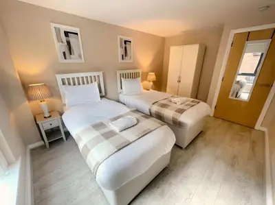 two beds in a small room with two lamps at 2BR City Centre Apt - Balcony - Sleeps 6 in Liverpool