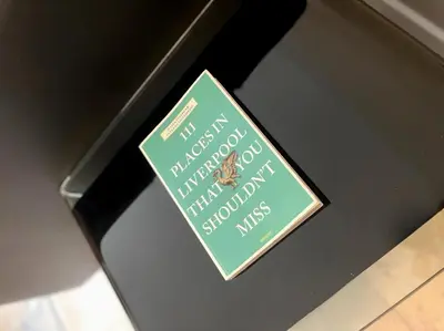 a book sitting on top of a shelf at City Centre 2BR Apartment, Free Parking! in Liverpool