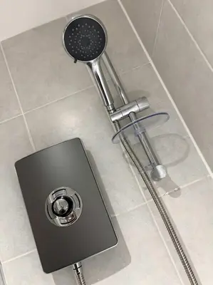 a shower with a shower head on a tile floor at City Centre 2BR Apartment, Free Parking! in Liverpool