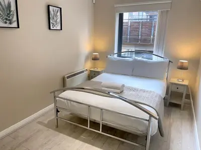 a small bedroom with a bed and a window at City Centre 2BR Apartment, Free Parking! in Liverpool