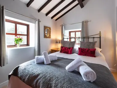 a bedroom with a large bed with red pillows at Wolfen Mill in Preston