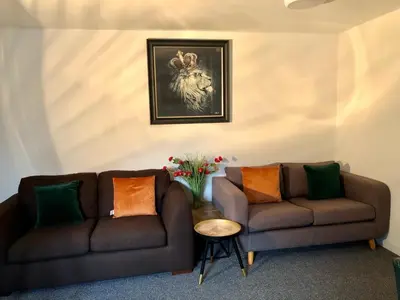 a living room with two brown couches and a painting at Three-Bedroom Superior Apartment - Sleeps 6 in Southport