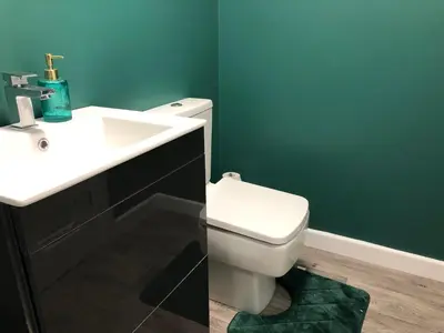 a bathroom with a white toilet and a sink at Three-Bedroom Superior Apartment - Sleeps 6 in Southport