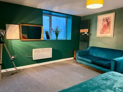 a living room with a blue couch and a window at Three-Bedroom Superior Apartment - Sleeps 6 in Southport