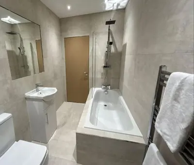 a bathroom with a tub and a toilet and a sink at Full Private House Sleeping 26 in Blackpool