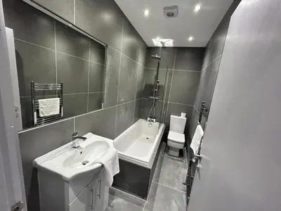 a bathroom with a sink and a tub and a toilet at Full Private House Sleeping 26 in Blackpool