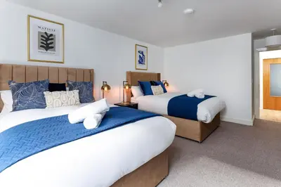 a bedroom with two beds with blue and white at Flatzy - Prime City Apartment with Free Parking & Ping Pong Table in Liverpool