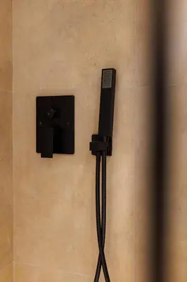 a phone on the wall of a shower at Flatzy - Prime City Apartment with Free Parking & Ping Pong Table in Liverpool